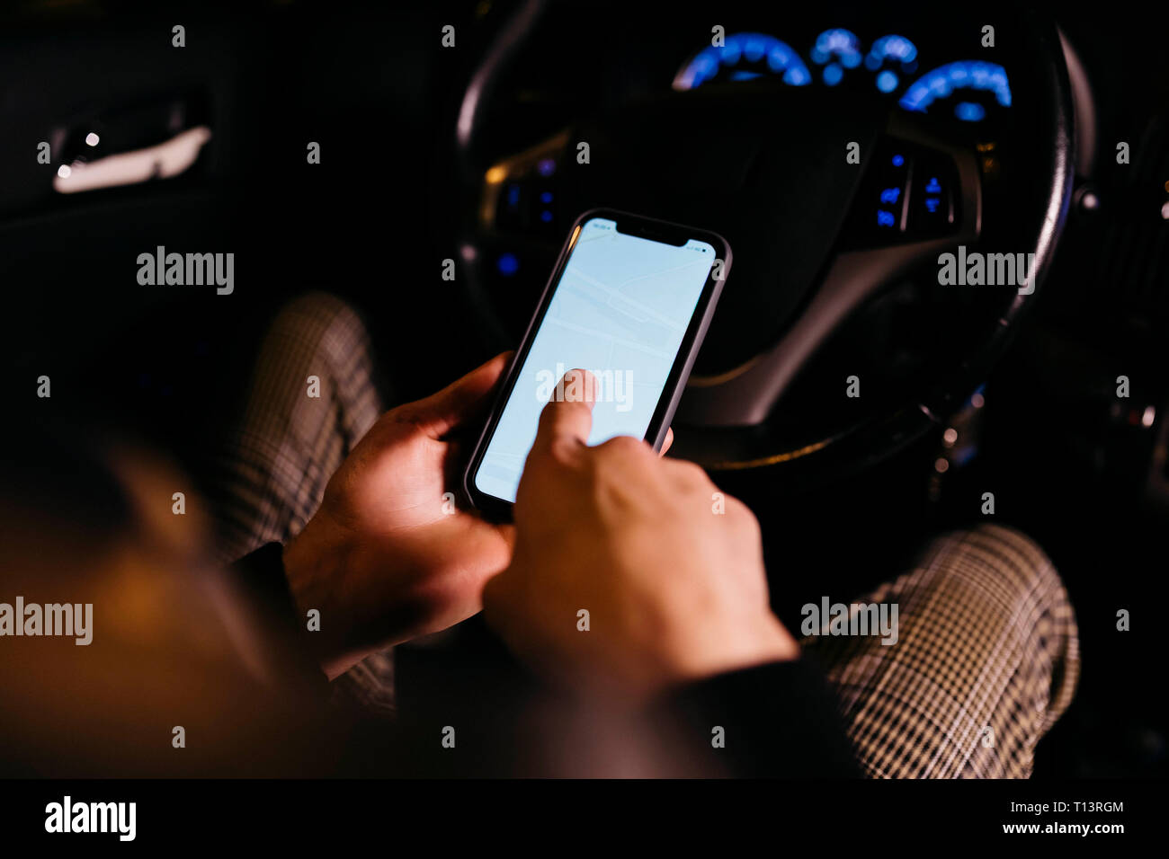 Man using cell phone in the car at night Stock Photo