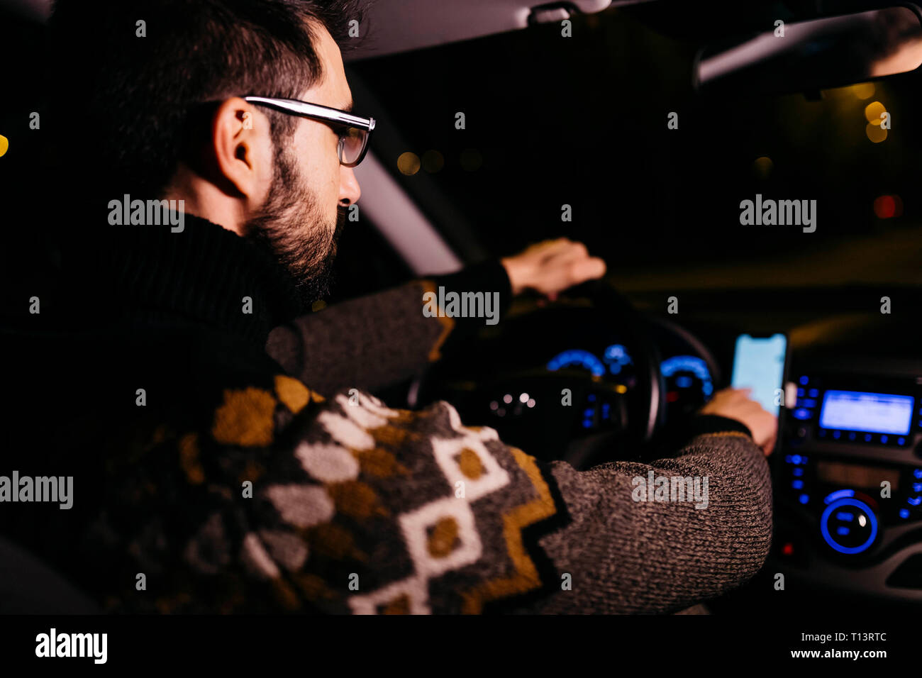 Man using cell phone with road maps in the car at night Stock Photo