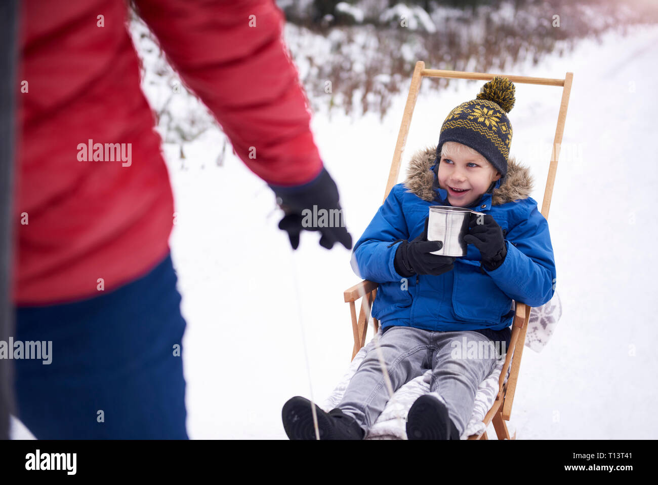 https://c8.alamy.com/comp/T13T41/portrait-of-smiling-little-boy-drinking-tea-while-his-father-pulling-the-sledge-T13T41.jpg