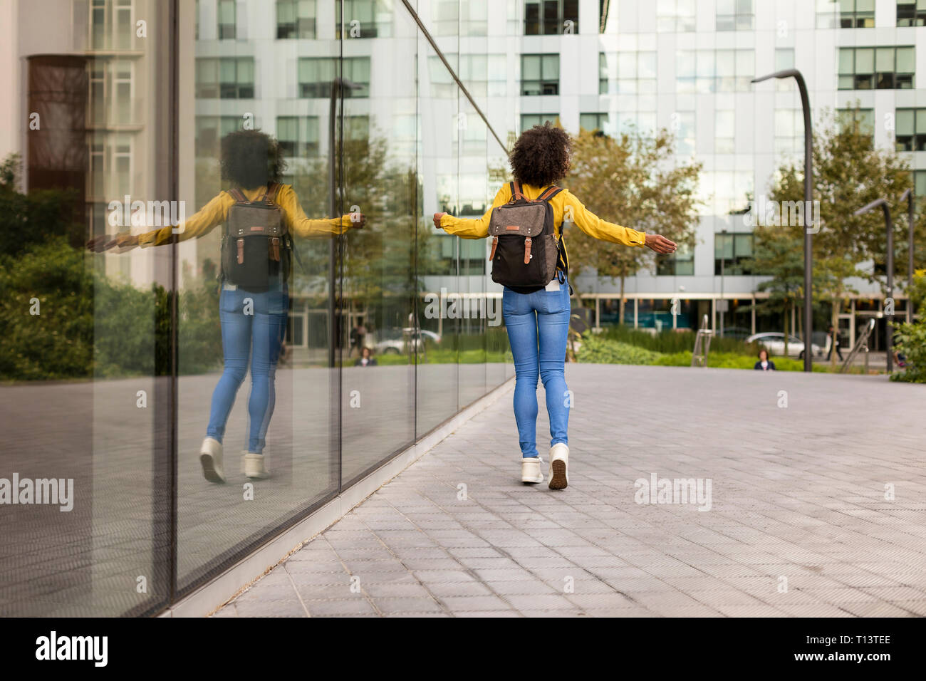 Back view of woman with backpack walking in the city Stock Photo - Alamy