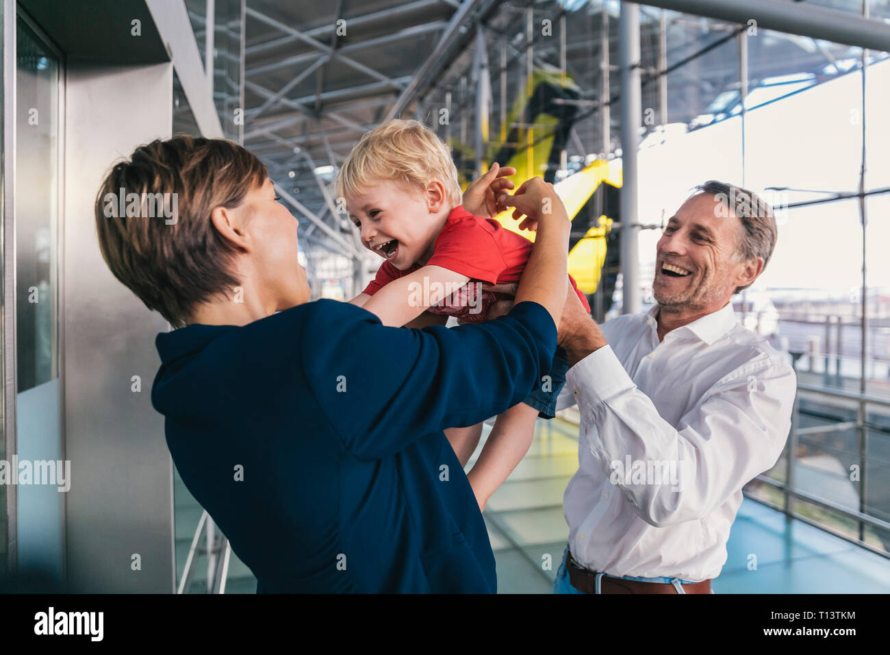Small boy being happy upon his business mother's arrival at the airport Stock Photo