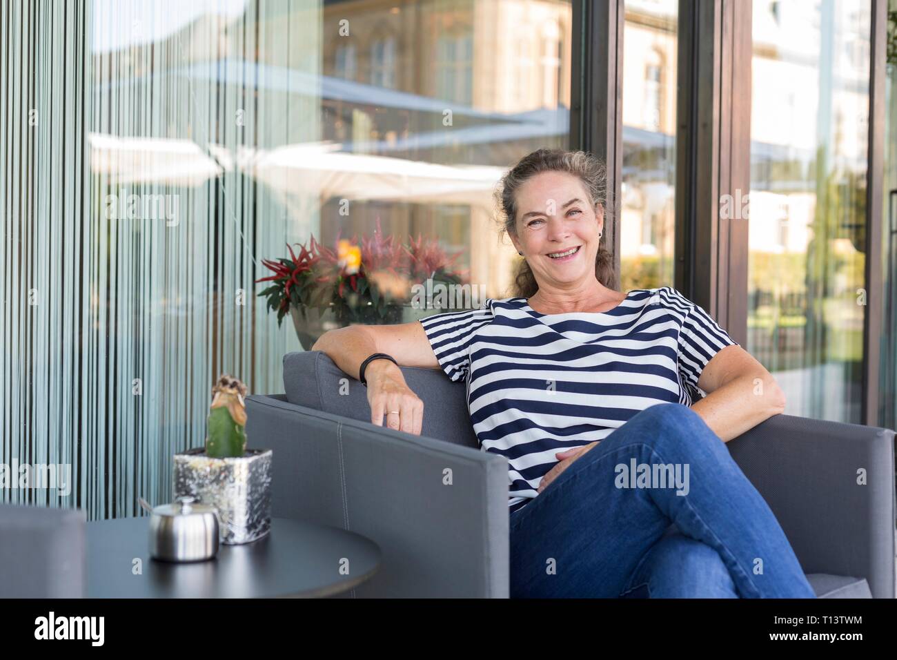 Portrait of laughing mature woman relaxing on terrace Stock Photo - Alamy