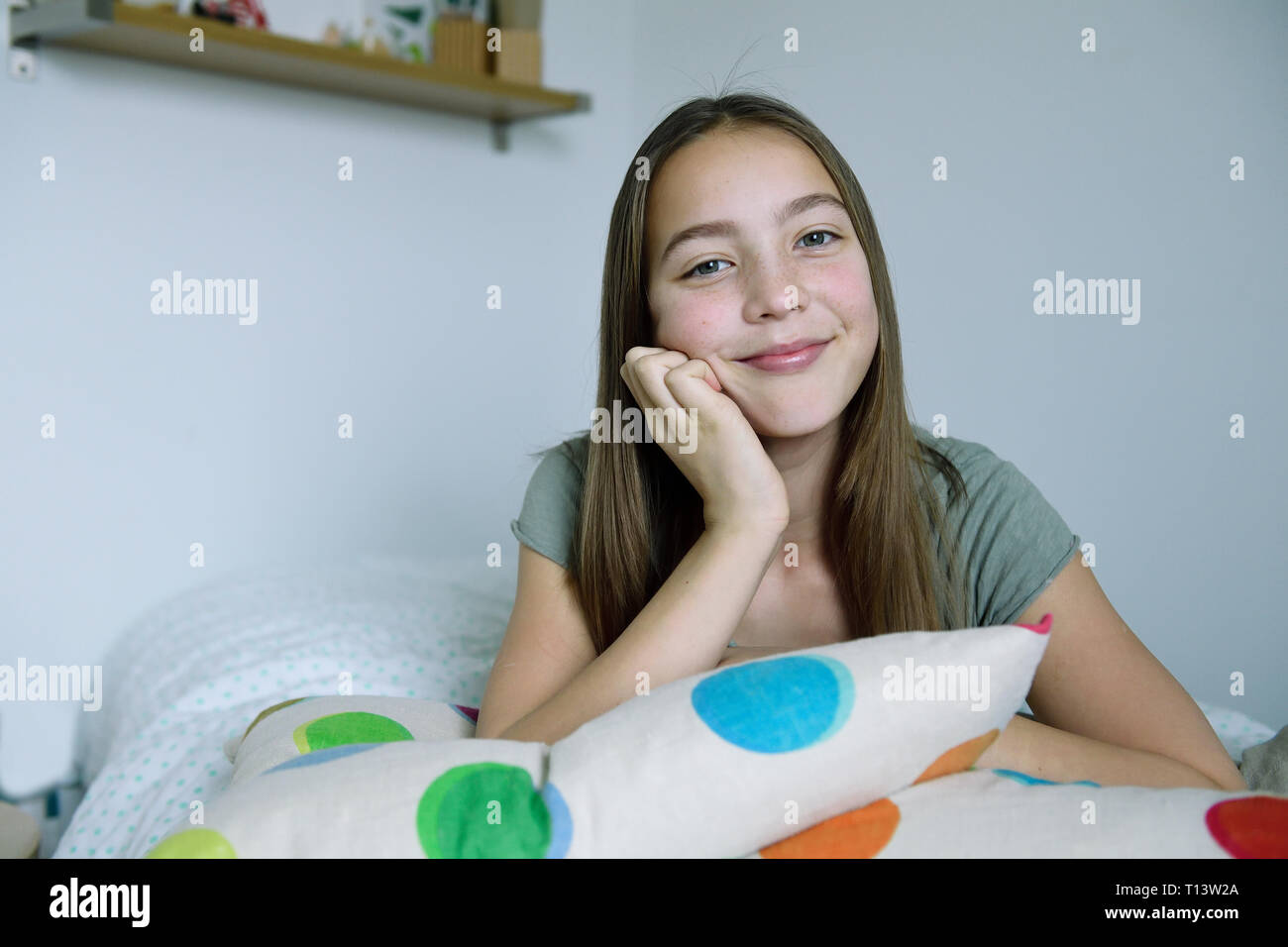 Portrait of smiling girl lying on bed Stock Photo Alamy