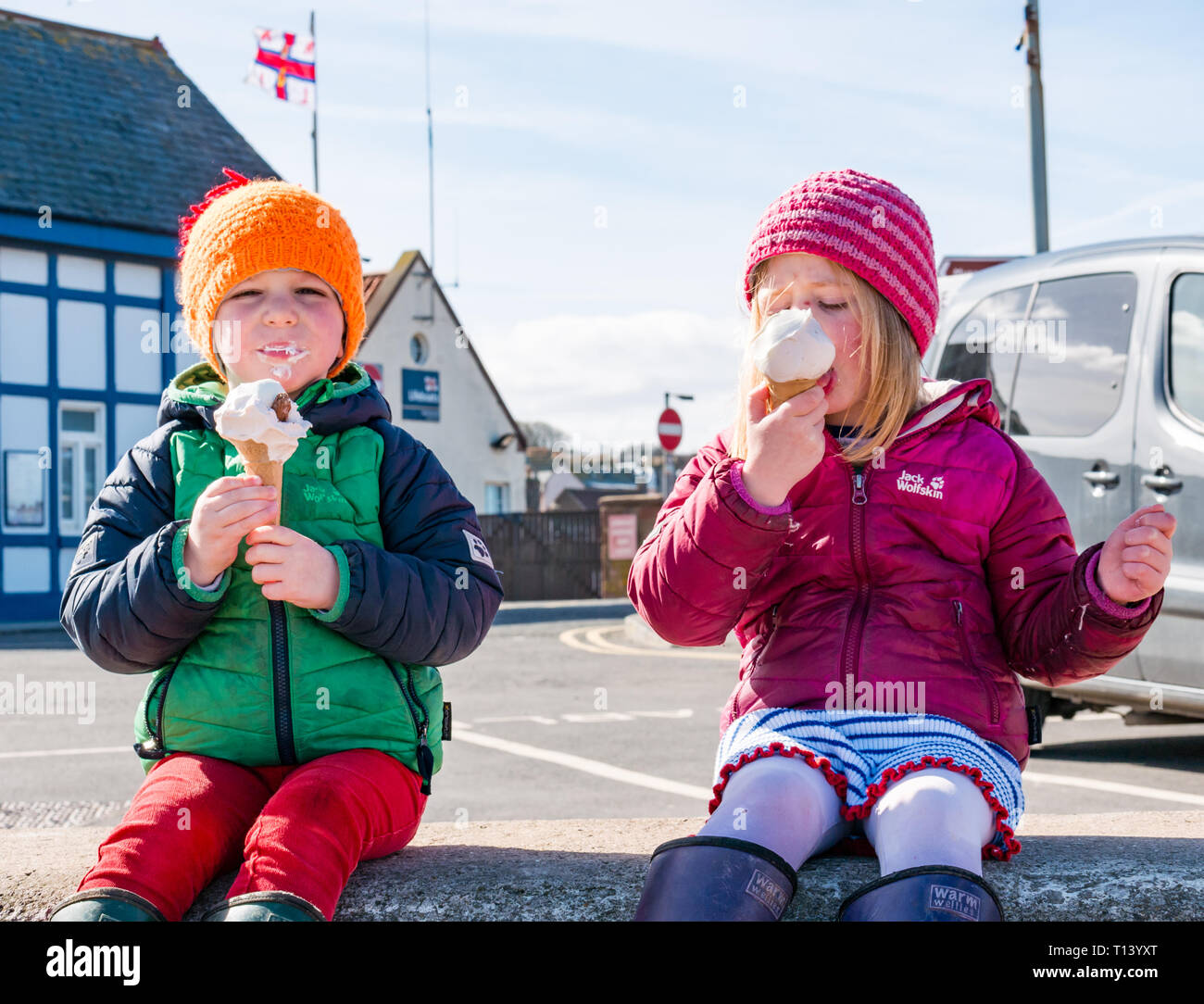 North Berwick, East Lothian, Scotland, UK, 23rd March 2019. UK Weather: Spring weather and sunshine at the seaside town. Two young children, Poppy and Ollie, enjoy a Luca ice cream despite the cool weather Stock Photo