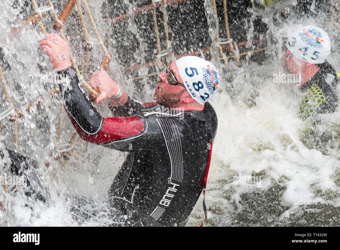 Maryhill, Glasgow, Scotland, UK. 23rd Mar, 2019. UK weather - a determined competitor braving 8 degree water temperatures at the Red Bull Neptune Steps swim/climb adventure endurance race at Maryhill Locks, Glasgow. The annual extreme event involves swimming 400m of cold canal water and climbing 18 metres over 7 canal lock gate obstacles Credit: Kay Roxby/Alamy Live News Stock Photo