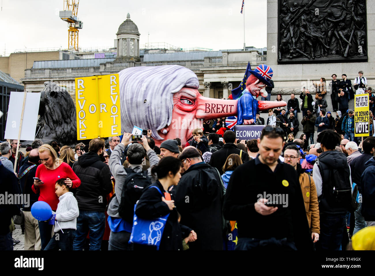Caricature of Theresa may, Brexit written on her nose, with her nose impaling a figure of a man holding two suitcases labelled 'The economy' The People's Vote March, London, March 2019 Stock Photo