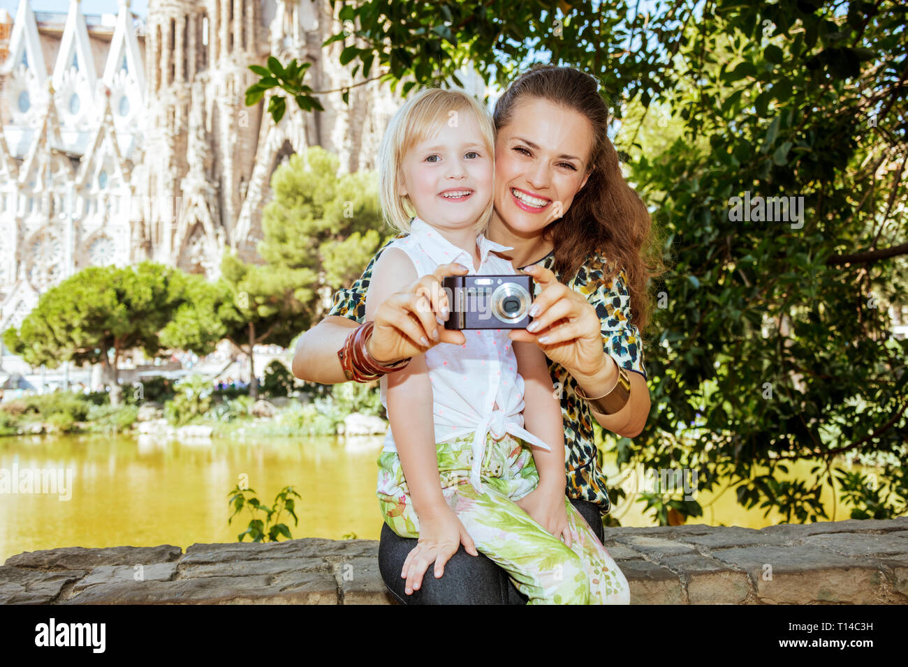 Barcelona - August, 06, 2015: smiling modern mother and child tourists taking photo with digital camera in Barcelona, Spain. Stock Photo