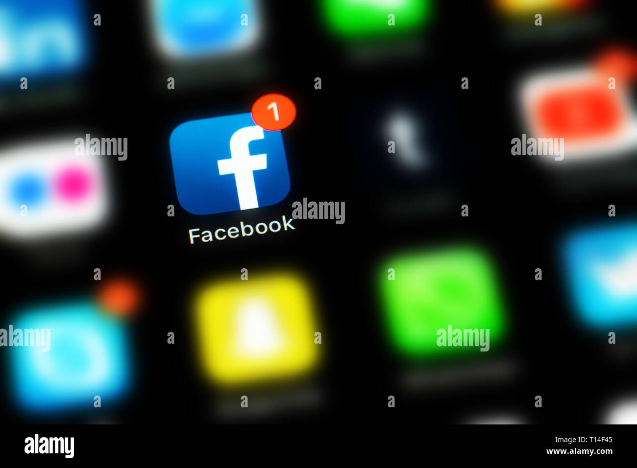 Apple iPhone X with icons of social media facebook and other blurred