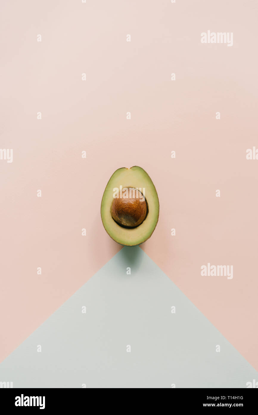 Top view on half avocado on minimalistic background Stock Photo
