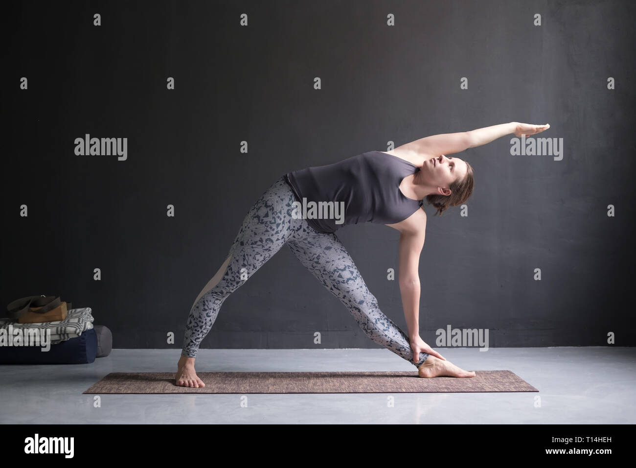 woman practicing yoga, doing Utthita Trikonasana pose Stock Photo