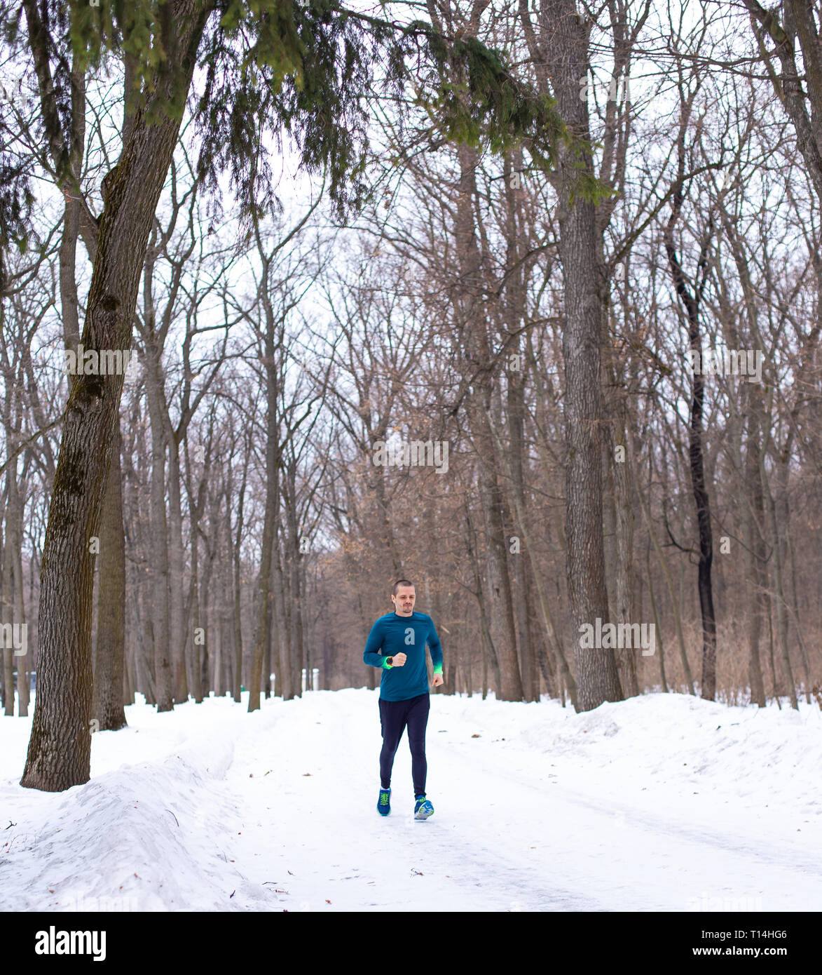 Man running in snow forest in winter Stock Photo