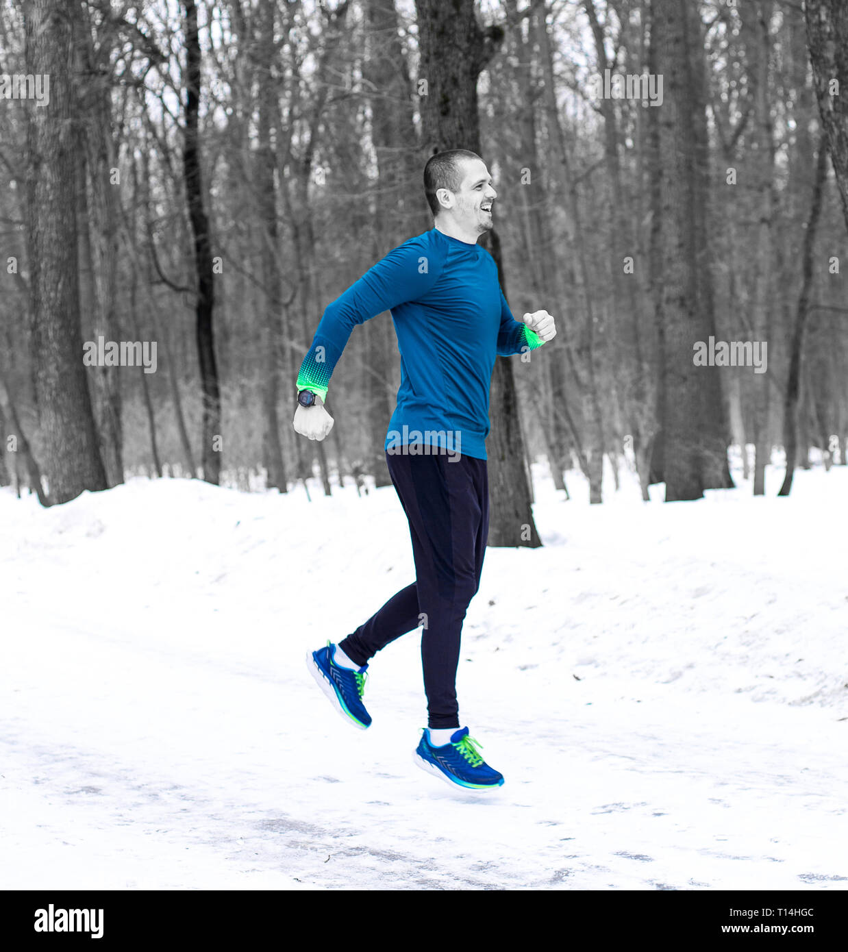 Sporty man jumping or running in winter forest Stock Photo