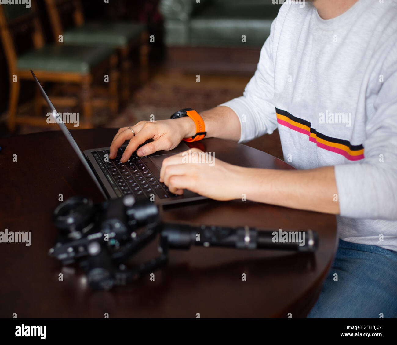 Laptop and camera on the table with hands of freelancer or blogger Stock Photo