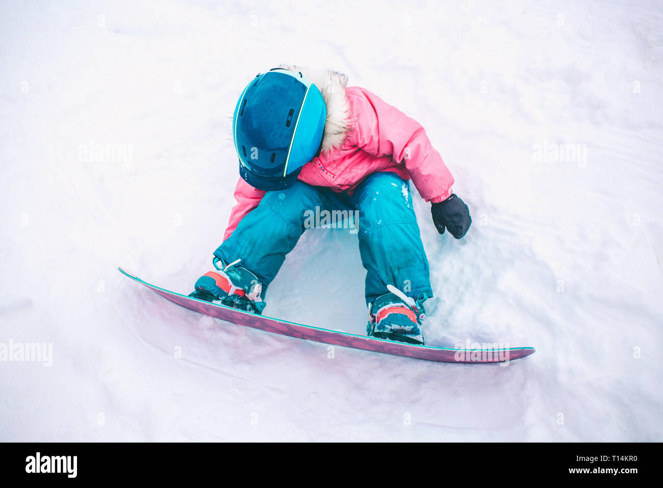 Little Cute 5 Years Old Girl Snowboarding making a Tricks at Ski