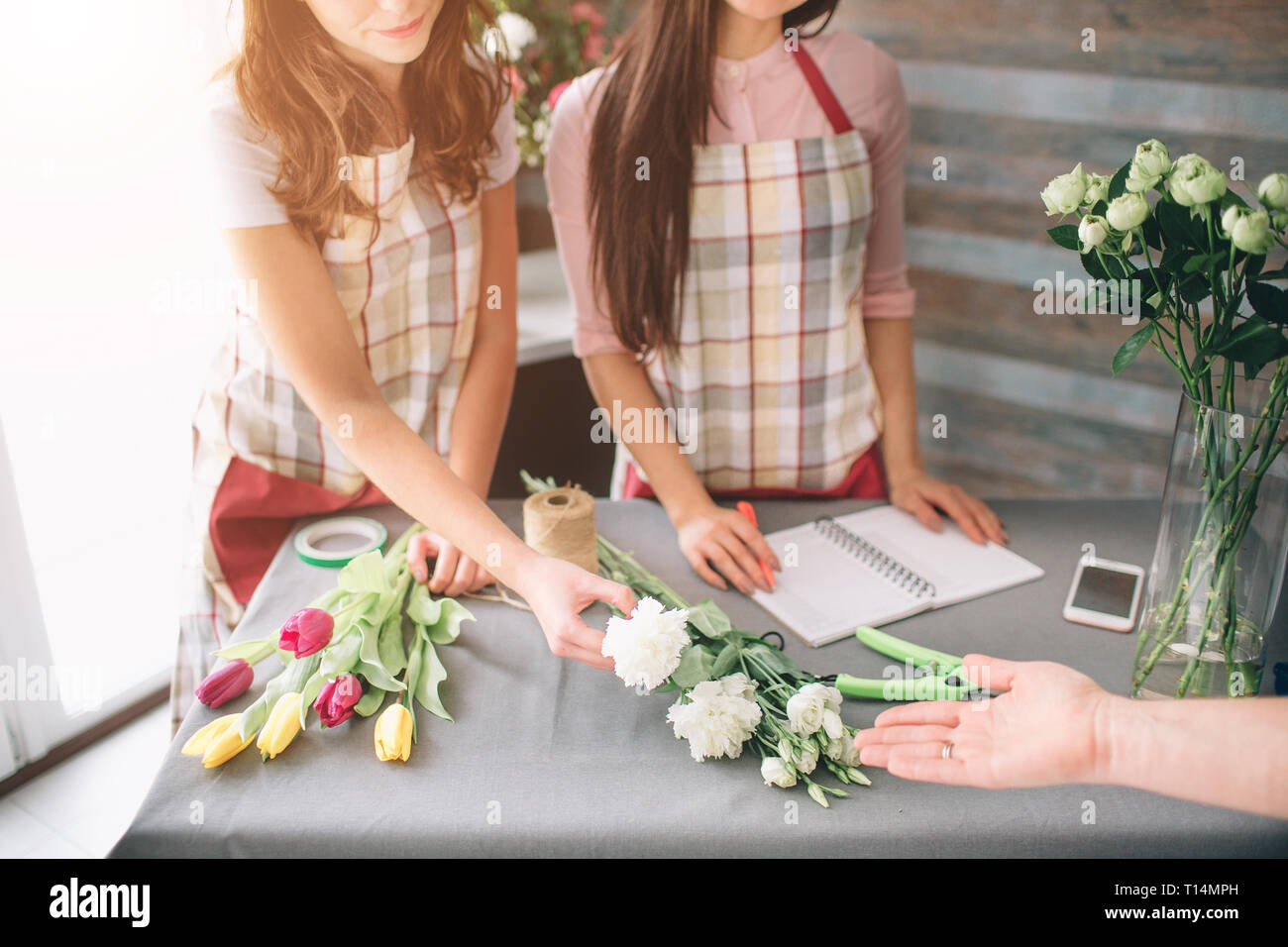 Flowers delivery top view. Florists creating order, making rose bouquet