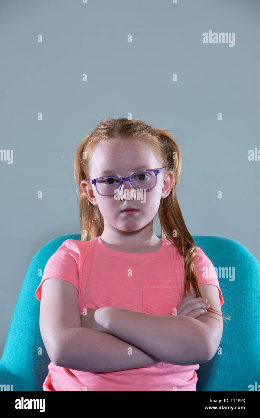 a bored young white girl with glasses and red hair. Stock Photo