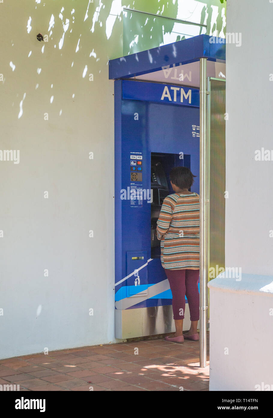 African lady or woman at an ATM machine in South Africa concept of technology or banking in Africa or African technology and lifestyle Stock Photo