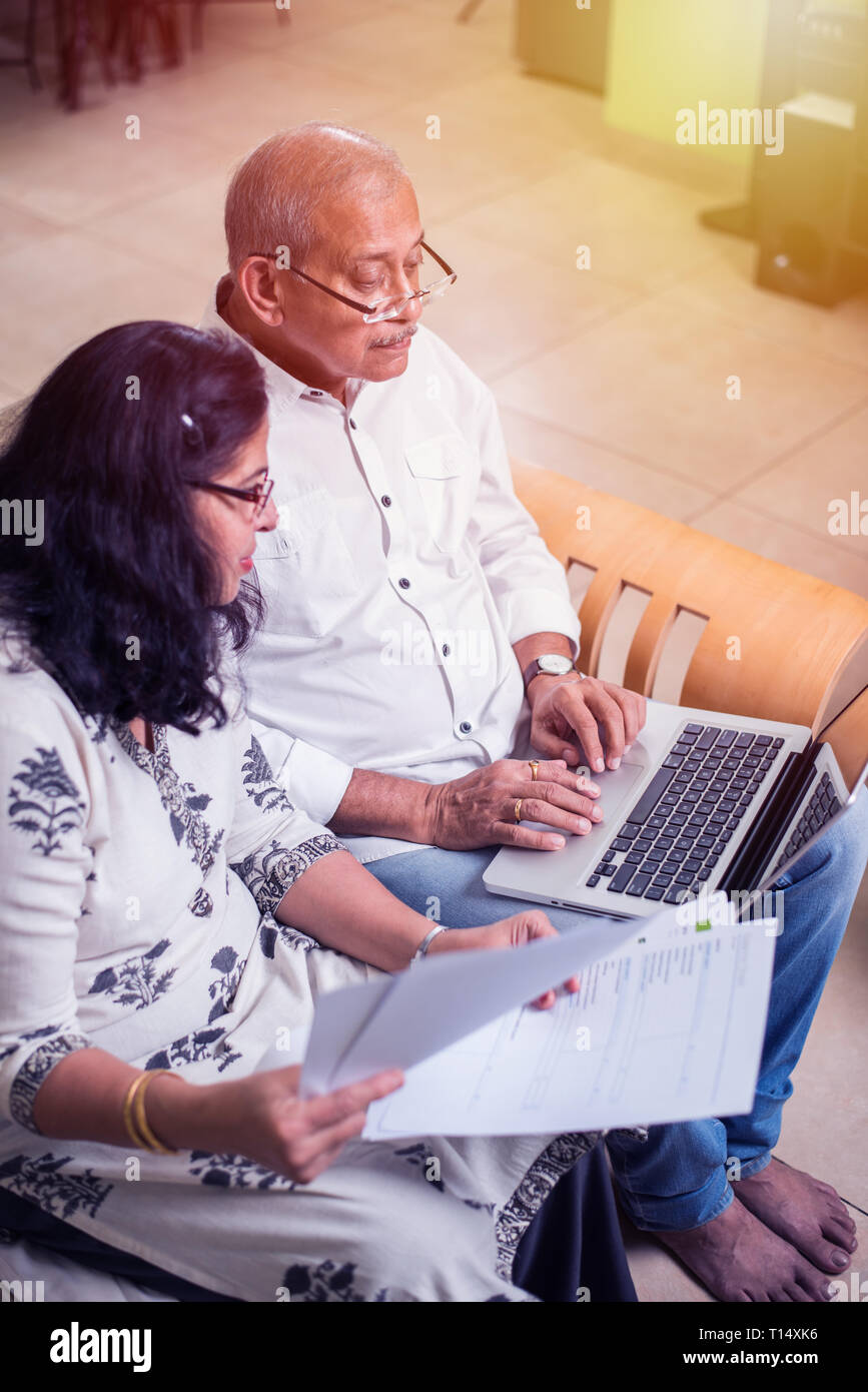 Senior Indian/asian couple accounting, doing home finance and checking