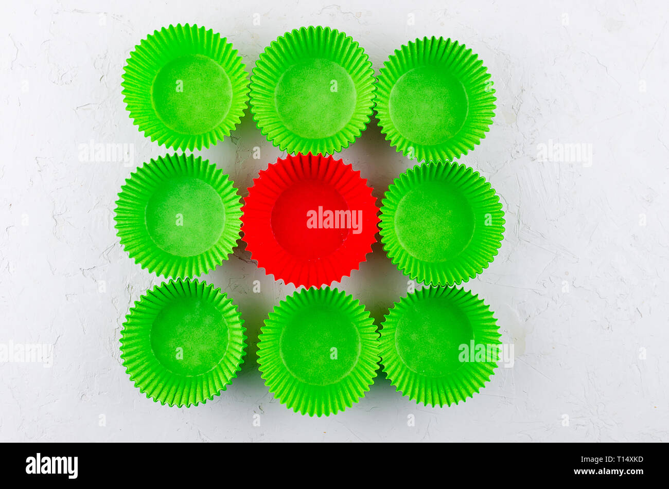 Brightly green and red colored paper baking cups for cupcakes or muffins on light grey conkrete background, copy space Stock Photo