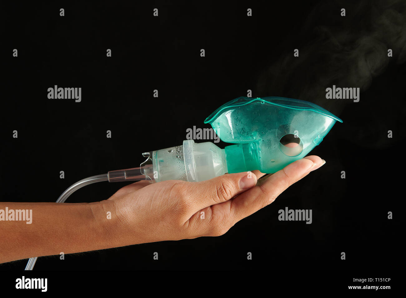 Inhalation mask with smoke on human palm isolated on black background Stock Photo Alamy