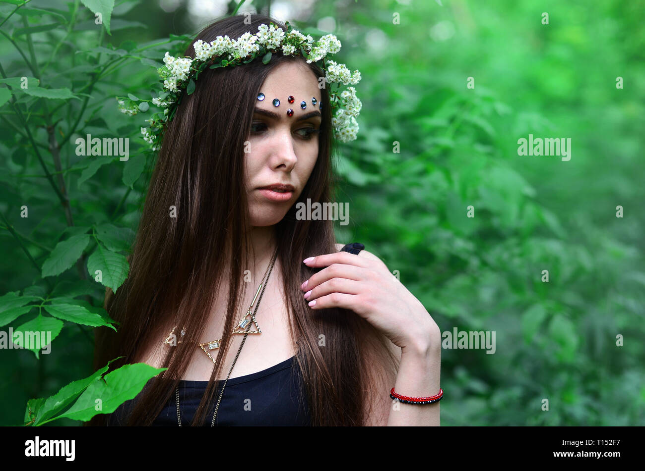 Portrait of an emotional young girl with a floral wreath on her head ...
