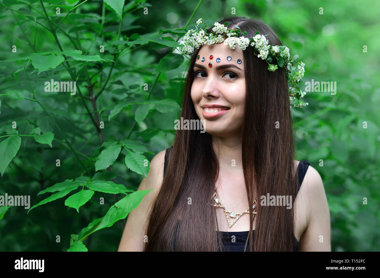 Portrait of an emotional young girl with a floral wreath on her head ...