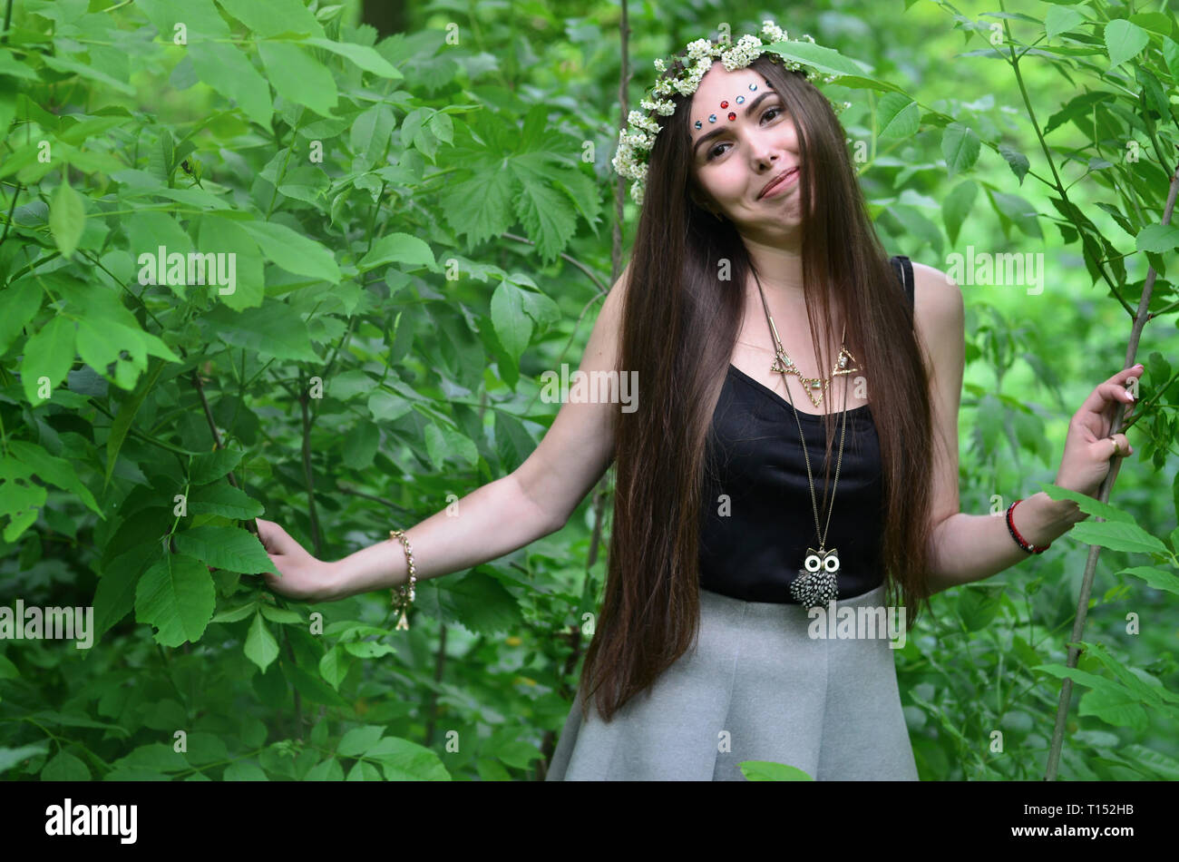Portrait of an emotional young girl with a floral wreath on her head ...