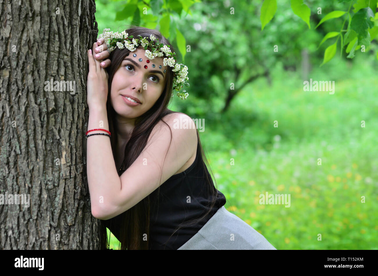Portrait of an emotional young girl with a floral wreath on her head ...
