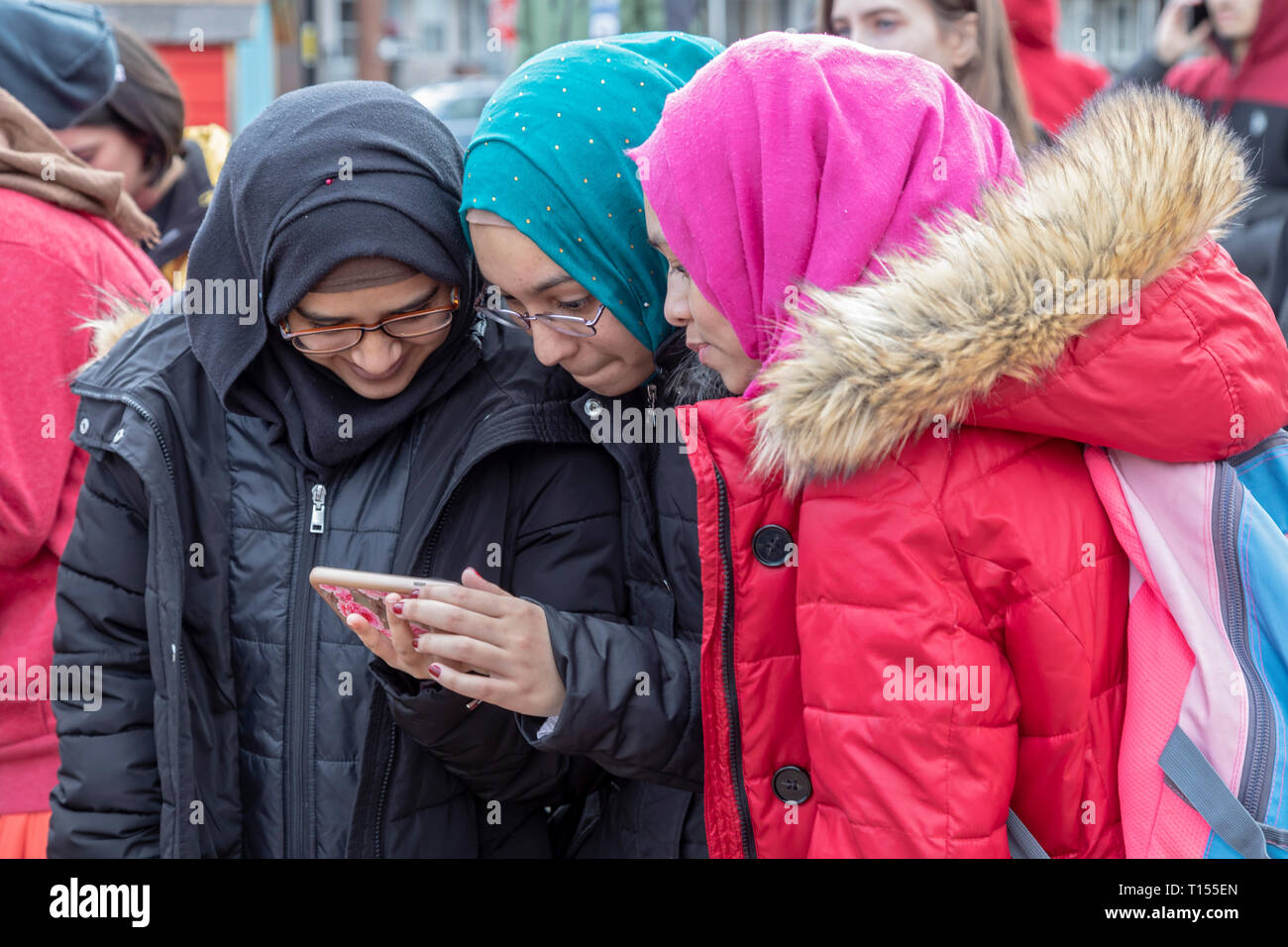 Hamtramck, Michigan - Muslim school girls study a cell phone. Hamtramck has always been a city of immigrants, most recently from Muslim countries. Ove Stock Photo