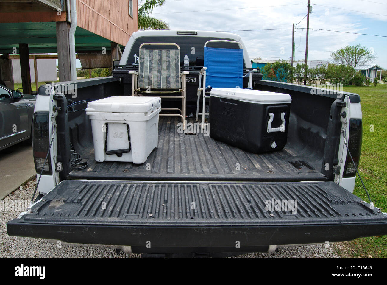 Pickup truck with lawn chairs and ice chests in the bed Stock Photo