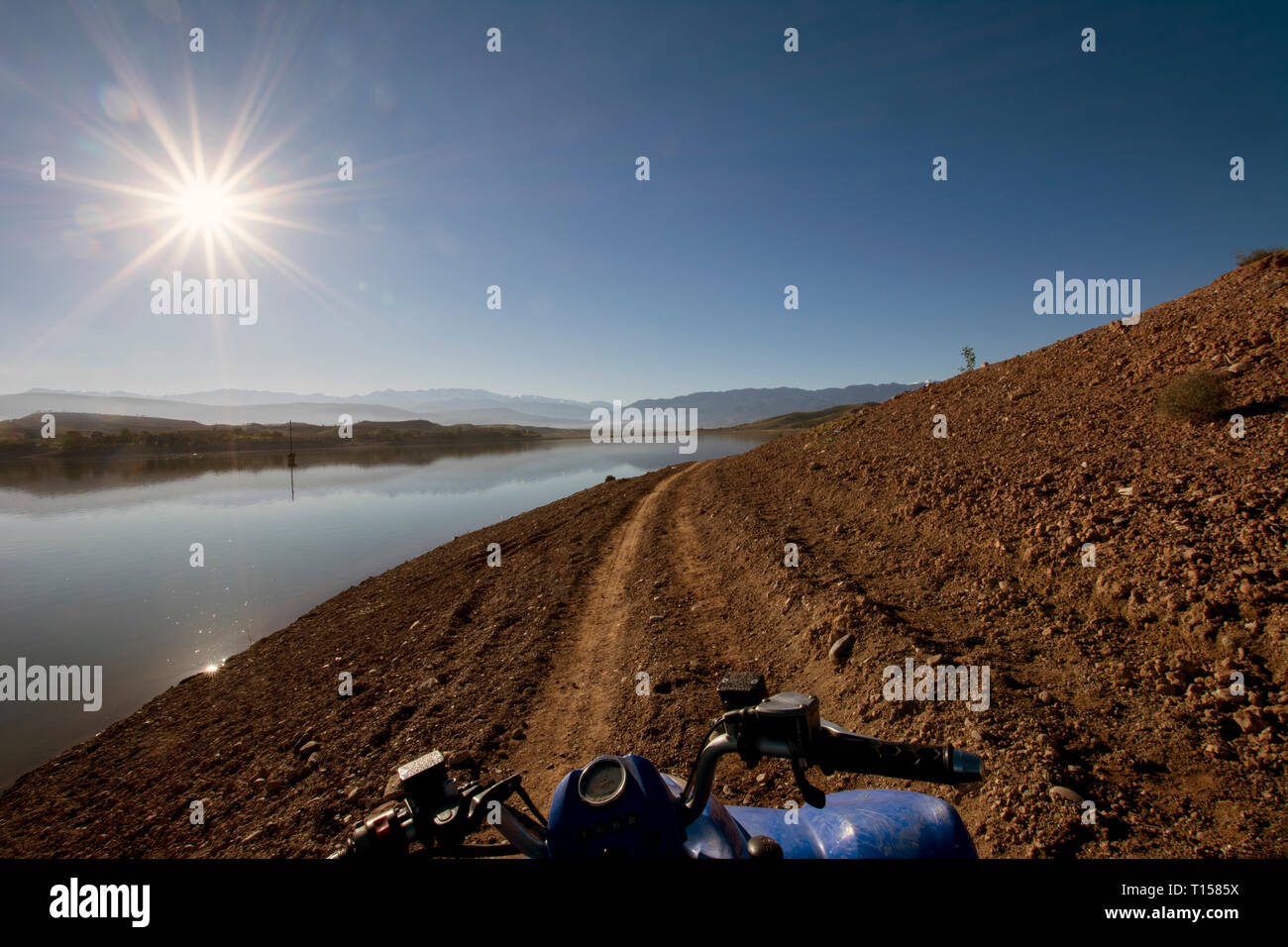 Morocco, Lalla Takerkoust, reservoir against the sun, quadbike in the foreground Stock Photo
