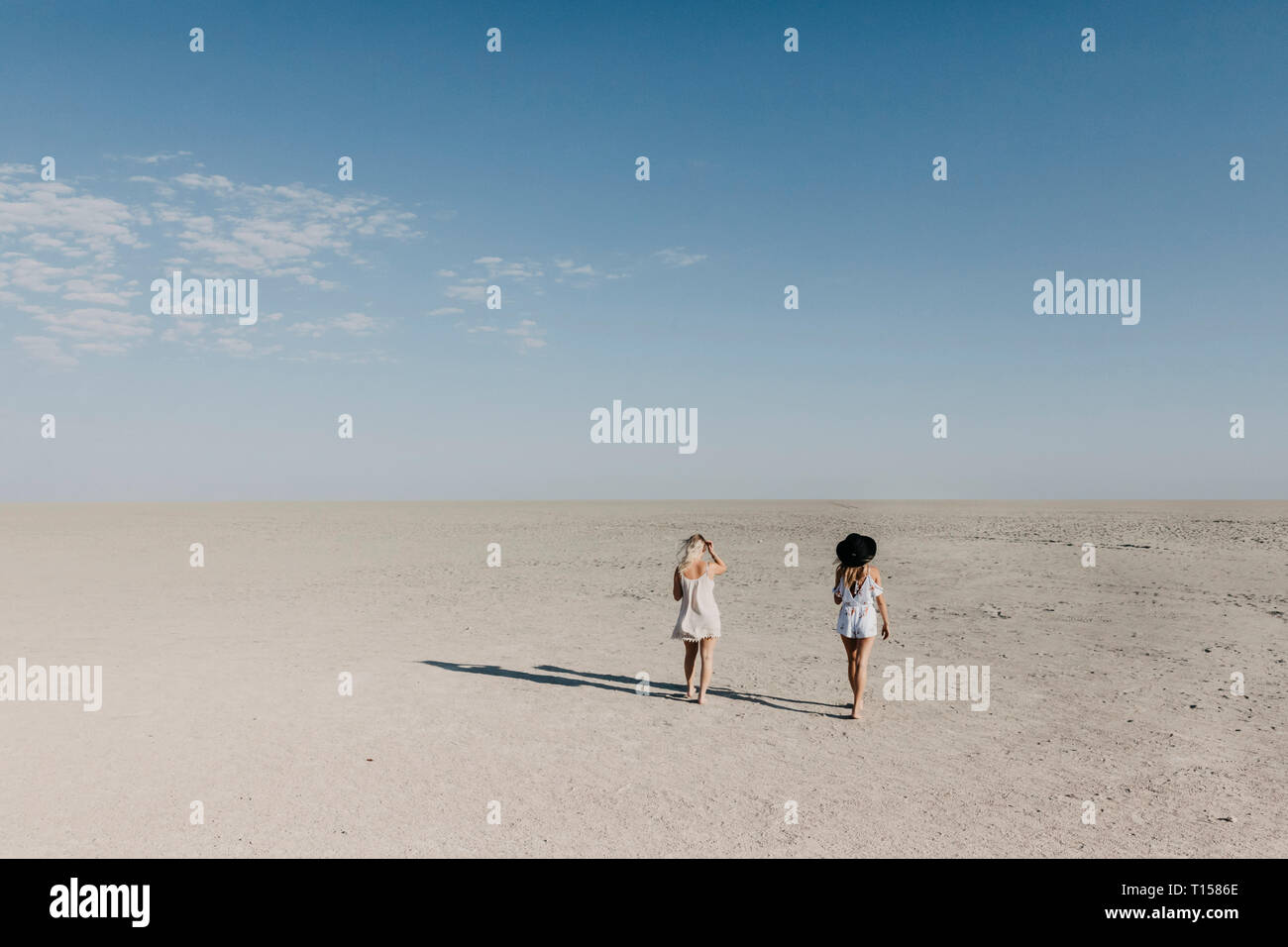 Two young women walking in the desert Stock Photo