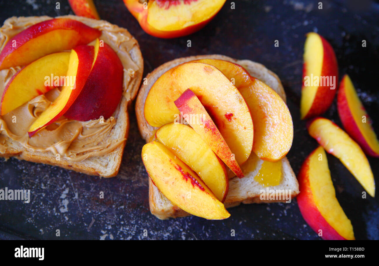 Fresh nectarine slices and peanut butter sandwich from overhead Stock Photo
