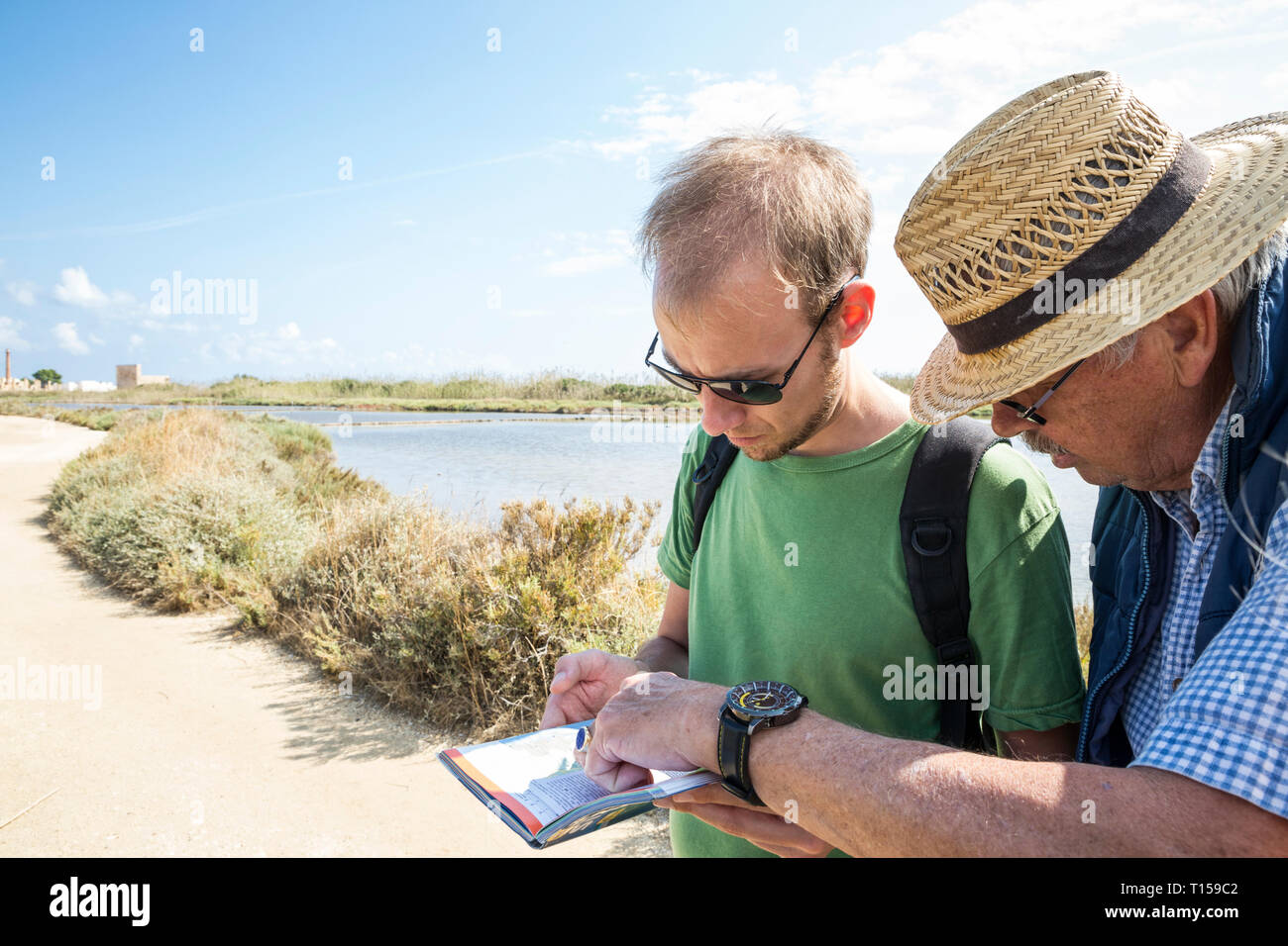 Italy, Sicily, Vendicari nature reserve, senior father and adult son looking at map Stock Photo
