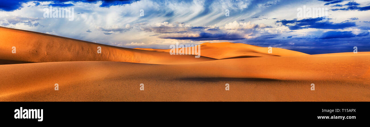 Endless arid lifeless desert of sand dunes in Australia - wide panorama under cloudy sky before storm - Stockton beach in Worimi national park. Stock Photo