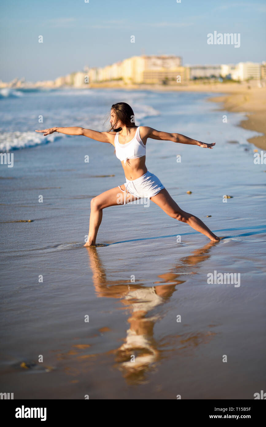 Sportive woman doing yoga on the beach Stock Photo