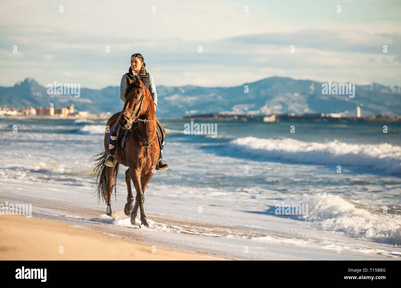 Spain, Tarifa, woman riding horse on the beach Stock Photo