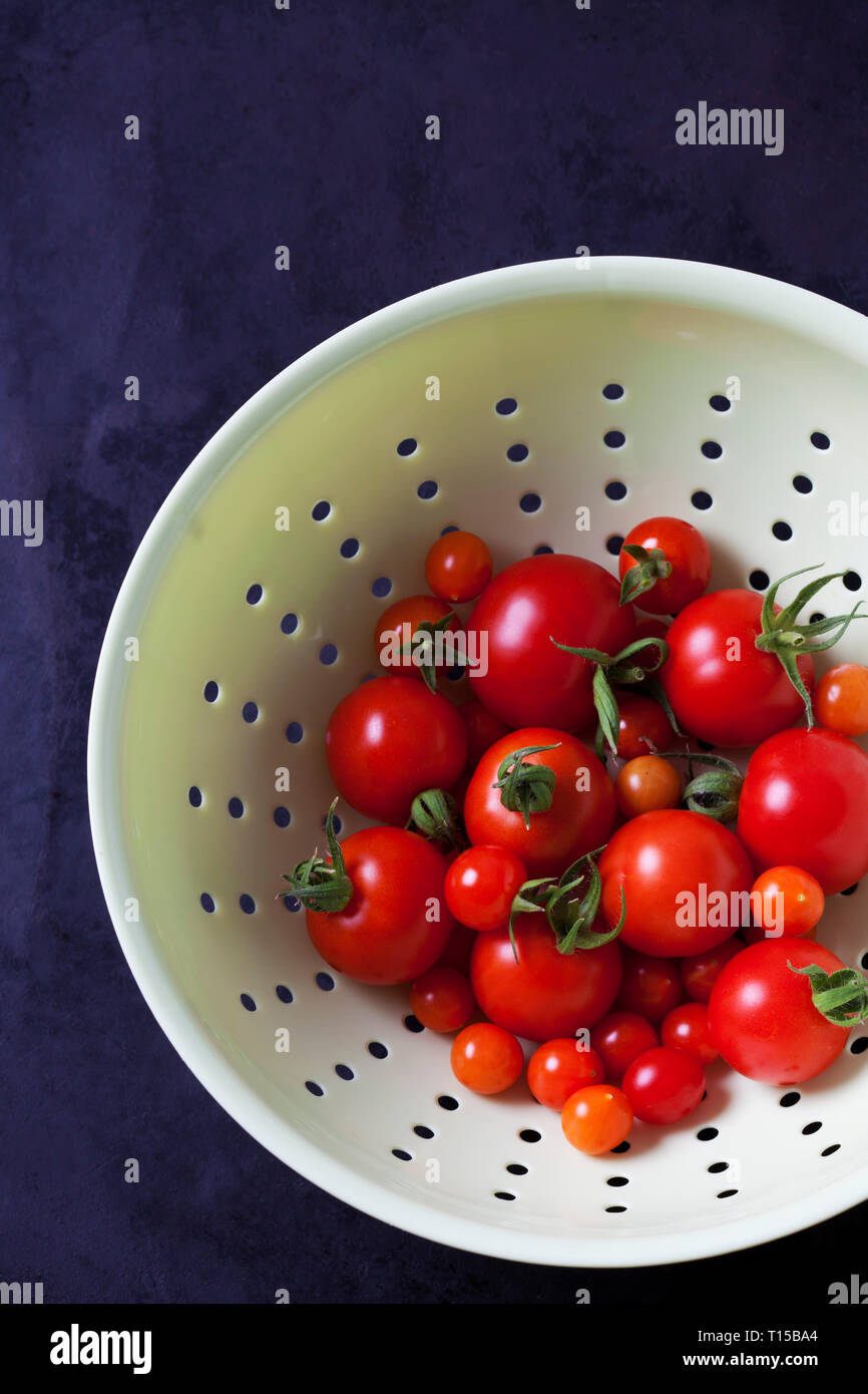 Currant tomatoes in white colander Stock Photo