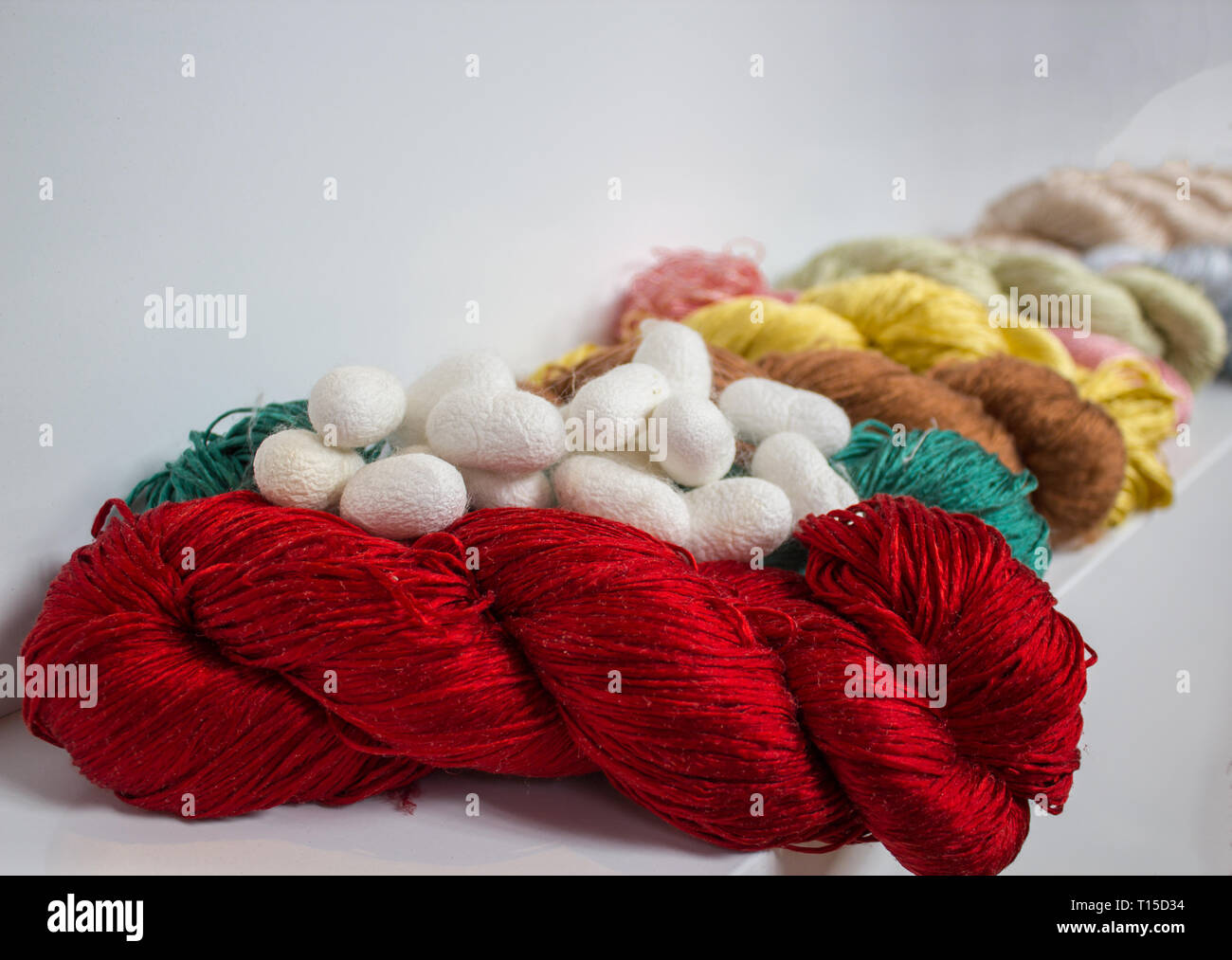 Colored silk threads and silk cocoons Stock Photo