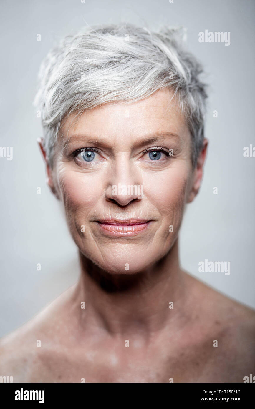 Portrait of mature woman with short grey hair and blue eyes Stock Photo