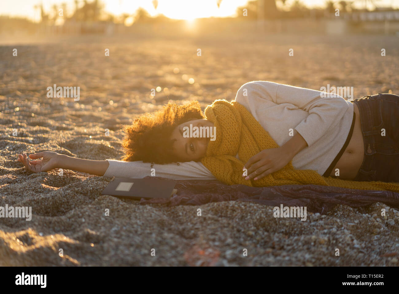 Woman lying in the sand, relaxing on the beach Stock Photo - Alamy