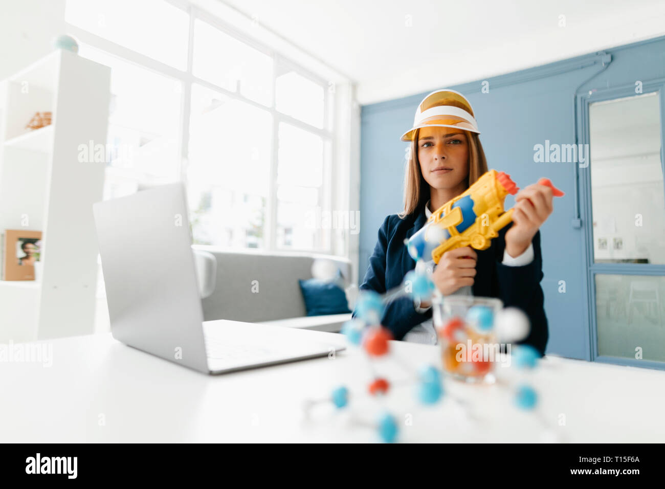 Female scientist holding water gun, studying molecules Stock Photo