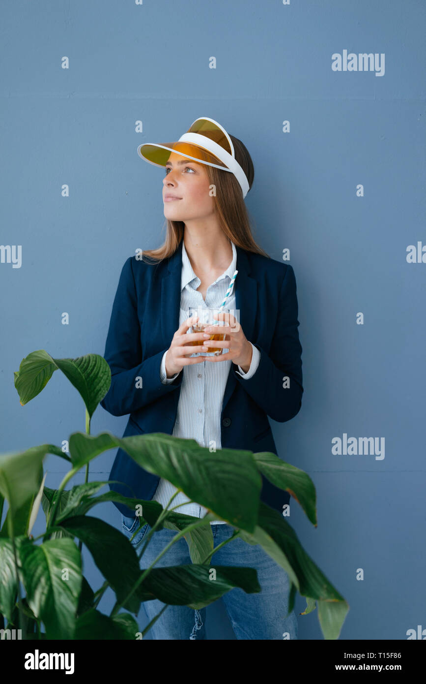 Portrait of a young businesswoman against blue background, dreaming of a holiday Stock Photo