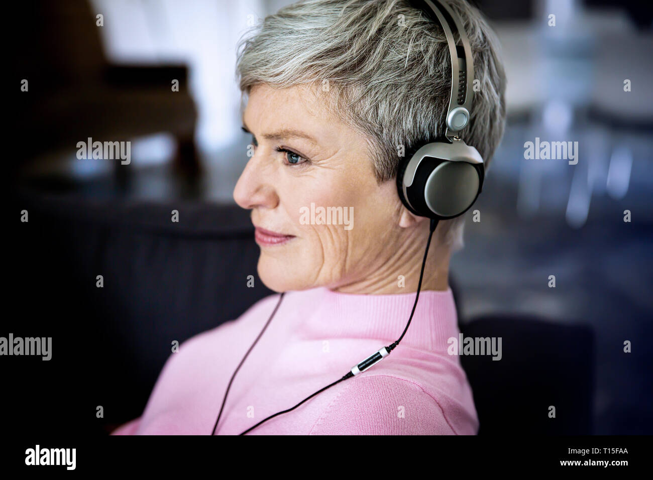 Content mature woman listening music with headphones at home Stock Photo Alamy
