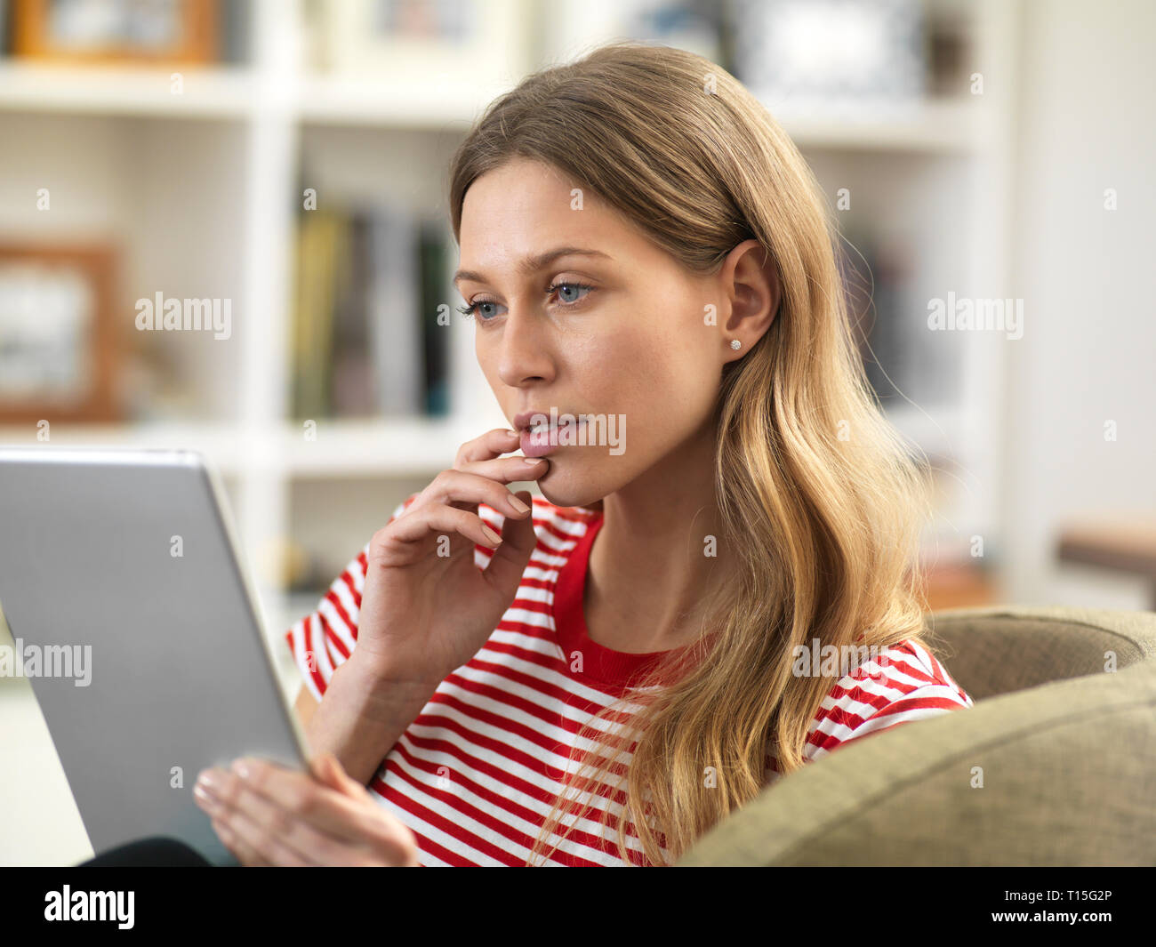 Young woman relaxing at home using a tablet Stock Photo