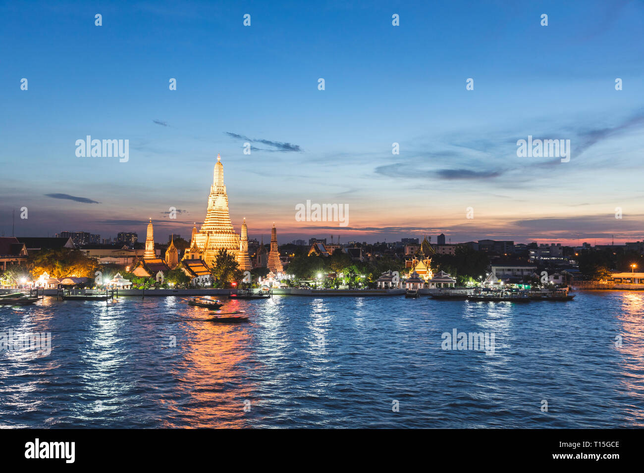 Thailand, Bangkok, Wat Arun temple at dusk with Chao Phraya river on foreground Stock Photo