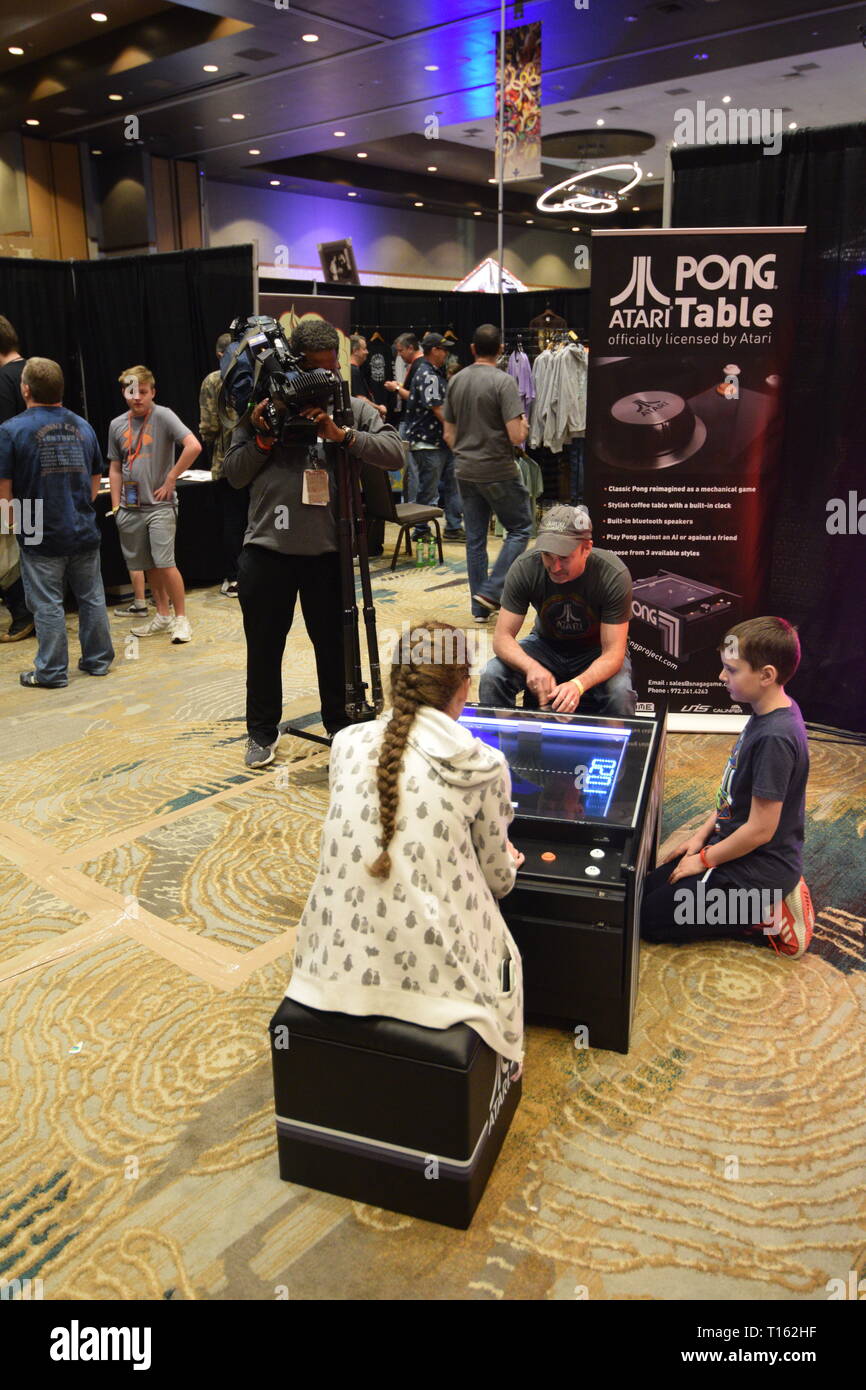 Frisco, USA. 23rd March, 2019.  Local news camera man filming a family as they play a vintage tabletop version of the Pong video game at the Texas Pinball Festival at the Embassy Suites Dallas – Frisco Hotel and Convention Center. Credit: Mariana Fernandez/Alamy Live News Stock Photo
