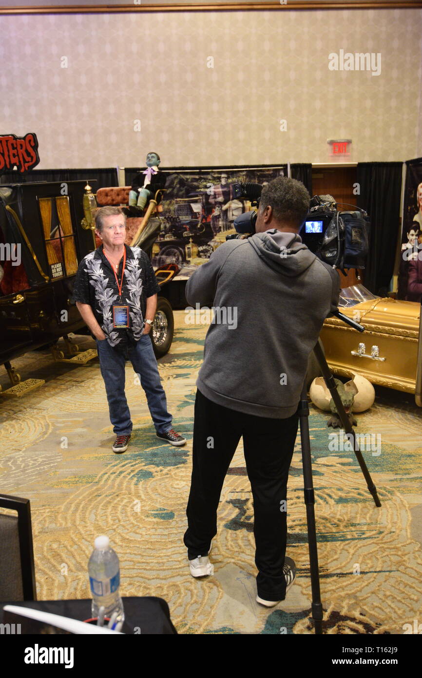 Frisco, USA. 23rd March, 2019.  Local news camera man records an interview segment with former child star and Munsters actor Butch Patrick at the Texas Pinball Festival at the Embassy Suites Dallas – Frisco Hotel and Convention Center. Credit: Mariana Fernandez/Alamy Live News Stock Photo