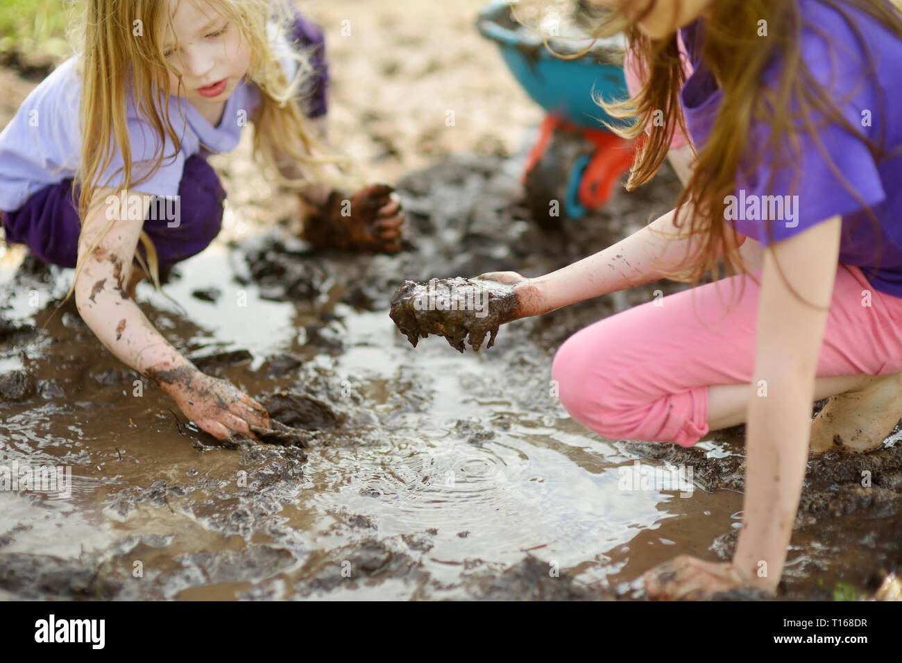 Two funny little girls playing in a large wet mud puddle on sunny summer day. Children getting dirty while digging in muddy soil. Messy games outdoors Stock Photo - Alamy Two funny little girls playing in a large wet mud puddle on sunny summer day. Children getting dirty while digging in muddy soil. Messy games outdoors Stock Photo - Alamy