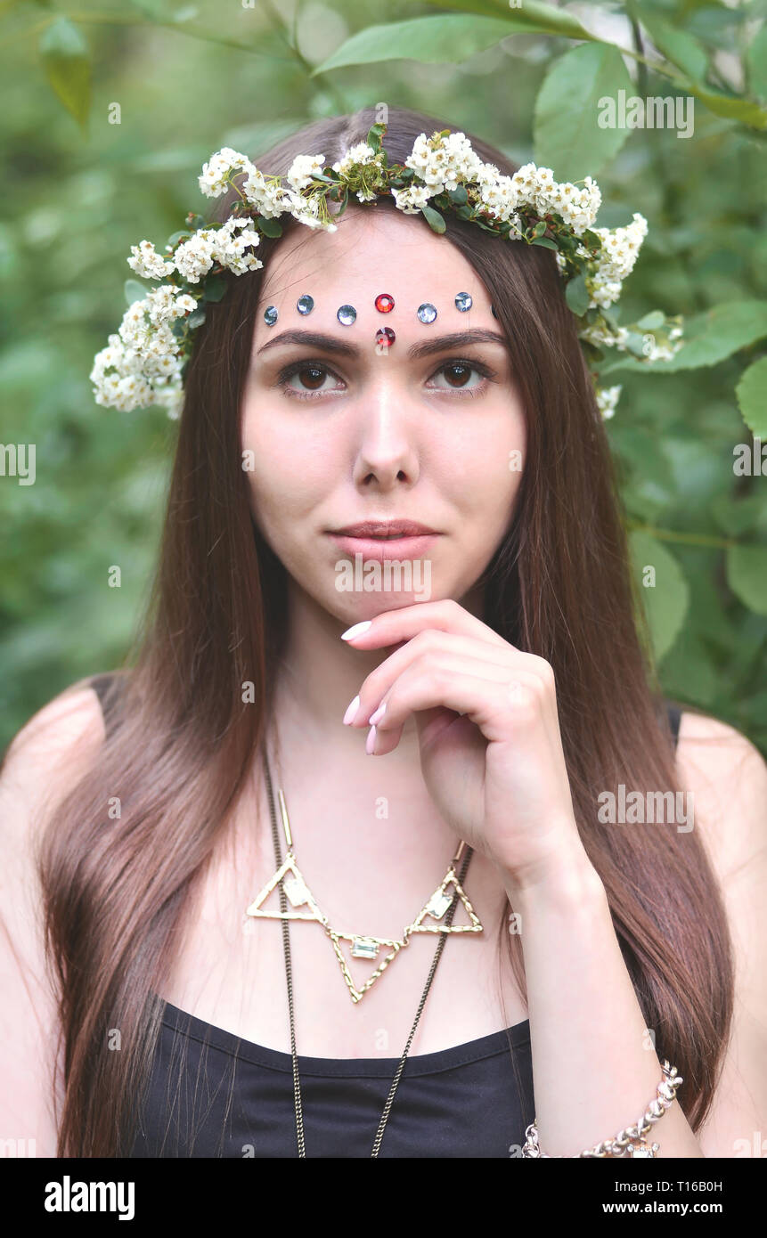 Portrait of an emotional young girl with a floral wreath on her head ...